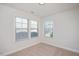Bedroom featuring neutral walls and carpet, with bright light from large windows at 103 Ballyliffen Ln, Cary, NC 27519