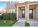 Charming townhome entrance featuring brick, a well manicured lawn, and a covered front porch at 103 Ballyliffen Ln, Cary, NC 27519