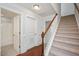 Hallway with carpeted stairs, hardwood floors, white trim, and access to bathroom at 103 Ballyliffen Ln, Cary, NC 27519