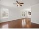 Open-concept living room with hardwood floors, large windows, and kitchen view at 103 Ballyliffen Ln, Cary, NC 27519