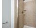Walk-in shower featuring tan tile and modern shower head and handle at 103 Ballyliffen Ln, Cary, NC 27519