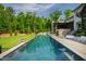 Backyard view of an inground pool, patio area with lounge chairs and lush green lawn at 103 Patriot Way, Apex, NC 27523