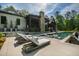 Outdoor living area with a stone fireplace, screened-in porch, sparkling pool and luxury loungers at 103 Patriot Way, Apex, NC 27523