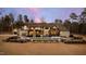 A luxurious backyard with an in-ground pool, outdoor seating, and a stone fireplace under a twilight sky at 103 Patriot Way, Apex, NC 27523