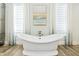 Luxurious bathroom displays a freestanding soaking tub with elegant fixtures and window views at 103 Patriot Way, Apex, NC 27523