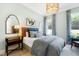 Bright bedroom with natural light, stylish gold light fixture and a woven headboard, creating a relaxing atmosphere at 103 Patriot Way, Apex, NC 27523