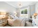 Comfortable bedroom showcases a bed with decorative pillows, bedside lamps, and a window view at 103 Patriot Way, Apex, NC 27523