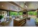 Spacious covered patio with an outdoor kitchen, stone fireplace, lounge area, dining table, and hot tub at 103 Patriot Way, Apex, NC 27523