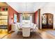 Formal dining room with a long wood table, chandelier, and a large window overlooking the landscaped front yard at 103 Patriot Way, Apex, NC 27523