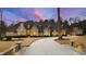 Stunning stone home showcasing manicured lawn, circular drive, and exquisite architectural detail at dusk at 103 Patriot Way, Apex, NC 27523