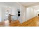 Bright hallway with wood floors, a decorative chandelier, and a staircase with ornamental iron spindles at 103 Patriot Way, Apex, NC 27523