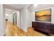Bright hallway with hardwood floors, a sliding barn door, and an archway leading to other rooms at 103 Patriot Way, Apex, NC 27523