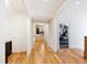 Hallway with hardwood floors and archways leading to a home gym and other living spaces at 103 Patriot Way, Apex, NC 27523