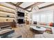 Cozy living room with stone fireplace, wood beams, and built-in shelves with modern lighting at 103 Patriot Way, Apex, NC 27523
