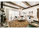 Large living room featuring a stone fireplace, exposed wood beams and a white sofa with an open floor plan at 103 Patriot Way, Apex, NC 27523