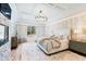 Bright primary bedroom boasts a decorative tray ceiling, an ornamental chandelier and a view to the backyard at 103 Patriot Way, Apex, NC 27523