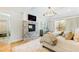 Serene bedroom with a stone fireplace, decorative chandelier, and natural light from the windows at 103 Patriot Way, Apex, NC 27523