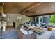 Covered outdoor living space with comfortable seating, outdoor kitchen, and adjacent pool area at 103 Patriot Way, Apex, NC 27523
