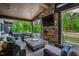 Inviting covered patio with stone fireplace, comfortable seating, and a glimpse of the swimming pool at 103 Patriot Way, Apex, NC 27523