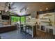 Outdoor space with stone fireplace, outdoor kitchen with breakfast bar, and views of the surrounding greenery at 103 Patriot Way, Apex, NC 27523