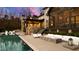 An outdoor living area featuring a luxury pool, covered patio, fire pit, and lounge furniture at 103 Patriot Way, Apex, NC 27523