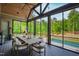 Inviting screened-in porch features an outdoor dining table, elegant lighting, and views of the pool at 103 Patriot Way, Apex, NC 27523