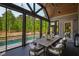 Inviting screened-in porch features an outdoor dining table, elegant lighting, and views of the backyard at 103 Patriot Way, Apex, NC 27523