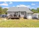 House with gray siding and a wooden deck, set in a backyard with both grass and bare patches at 106 Northwinds Dr, Wendell, NC 27591