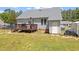 Backyard with a wooden deck attached to a house with gray siding and a fenced-in yard at 106 Northwinds Dr, Wendell, NC 27591