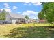 This backyard features a mix of grass and bare patches with a house with a wooden deck at 106 Northwinds Dr, Wendell, NC 27591