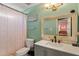 This bathroom features a white sink vanity and toilet and includes a shower with a pale pink curtain at 106 Northwinds Dr, Wendell, NC 27591