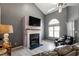 Comfortable living room features a fireplace, large window, ceiling fan, and a leather couch at 106 Northwinds Dr, Wendell, NC 27591