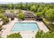 Aerial view of the community pool and clubhouse surrounded by lush greenery and trees at 107 Oxford Creek Rd, Cary, NC 27519
