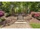 Beautiful backyard with stone steps leading to a lush garden area, providing a serene retreat at 107 Oxford Creek Rd, Cary, NC 27519