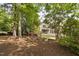 Large landscaped backyard featuring flowering bushes and leafy trees at 107 Oxford Creek Rd, Cary, NC 27519
