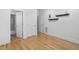 Spacious bedroom featuring hardwood floors, modern shelving, and adjacent bathroom entrance at 107 Oxford Creek Rd, Cary, NC 27519