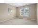 Neutral carpeted bedroom featuring a large window with plantation shutters and neutral paint at 107 Oxford Creek Rd, Cary, NC 27519