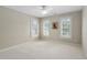 Neutral carpeted bedroom featuring natural light from three shuttered windows at 107 Oxford Creek Rd, Cary, NC 27519