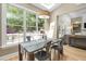 Sunlit dining area with large windows offering views of the deck, hardwood floors, and open to the living room at 107 Oxford Creek Rd, Cary, NC 27519