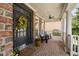 Inviting front porch features brick flooring, ceiling fan, and comfortable seating at 107 Oxford Creek Rd, Cary, NC 27519