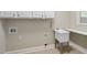 A functional laundry room equipped with a utility sink, cabinet storage, and neutral walls at 107 Oxford Creek Rd, Cary, NC 27519