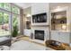 Cozy living room featuring a fireplace with built-in shelving, large windows, and hardwood floors at 107 Oxford Creek Rd, Cary, NC 27519