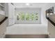 Bright living room featuring large windows, neutral walls, ceiling fan, and built-in shelving and cabinetry at 107 Oxford Creek Rd, Cary, NC 27519
