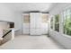 Bright living room with hardwood-style floors featuring windows, ceiling fan, and built-in shelving and cabinetry at 107 Oxford Creek Rd, Cary, NC 27519