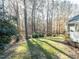 Lush backyard with mature trees providing shade and privacy, offering a serene outdoor space at 11 Whitburn Pl, Durham, NC 27705