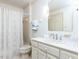 Bright bathroom featuring a shower with patterned curtain, white vanity, and large mirror at 11 Whitburn Pl, Durham, NC 27705