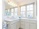 A bright bathroom featuring a double vanity with marble countertops and a large window at 11 Whitburn Pl, Durham, NC 27705
