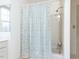 This is a bathroom featuring a shower with a gray patterned shower curtain and a window at 11 Whitburn Pl, Durham, NC 27705