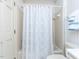This is a bathroom featuring a toilet and a tiled shower with patterned shower curtain at 11 Whitburn Pl, Durham, NC 27705