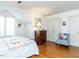 This bedroom features hardwood floors, a bed with white bedding, and large closet doors at 11 Whitburn Pl, Durham, NC 27705